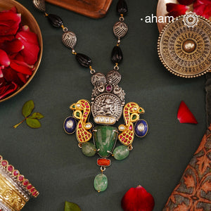 We thrive to bring alive traditional forms in new avatars. This Noori dual tone neckpiece is  crafted in 92.5 sterling silver using intricate nakshi work ganesha in the center, tumbled emerals , lapiz and coral highlights. Comes with a unique chain to complement the whole look, A perfect piece for intimate weddings and upcoming festive celebrations. 