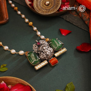 We thrive to bring alive traditional forms in new avatars. This Noori dual tone neckpiece crafted in 92.5 sterling silver with intricate Krishna nakshi work motif in the center, tumbled emeralds on either sides, kundan highlights and a unique pearl chain to elevate the entire piece. A piece perfect for intimate weddings and upcoming festive celebrations. 