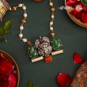 We thrive to bring alive traditional forms in new avatars. This Noori dual tone neckpiece crafted in 92.5 sterling silver with intricate Krishna nakshi work motif in the center, tumbled emeralds on either sides, kundan highlights and a unique pearl chain to elevate the entire piece. A piece perfect for intimate weddings and upcoming festive celebrations. 