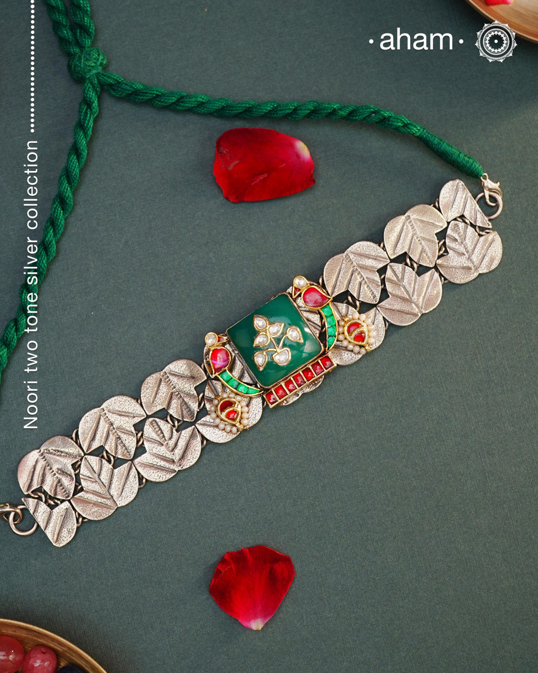 Elevate your style with the Noori Parrot Two Tone Silver Choker. This captivating piece features intricately crafted parrots and a stunning green stone, all set in 92.5 silver with two tones. Versatile and timeless, it is the perfect addition to any outfit. Invest in this modern heirloom for years to come.