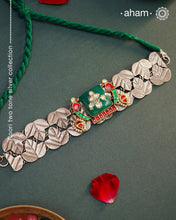 Elevate your style with the Noori Parrot Two Tone Silver Choker. This captivating piece features intricately crafted parrots and a stunning green stone, all set in 92.5 silver with two tones. Versatile and timeless, it is the perfect addition to any outfit. Invest in this modern heirloom for years to come.