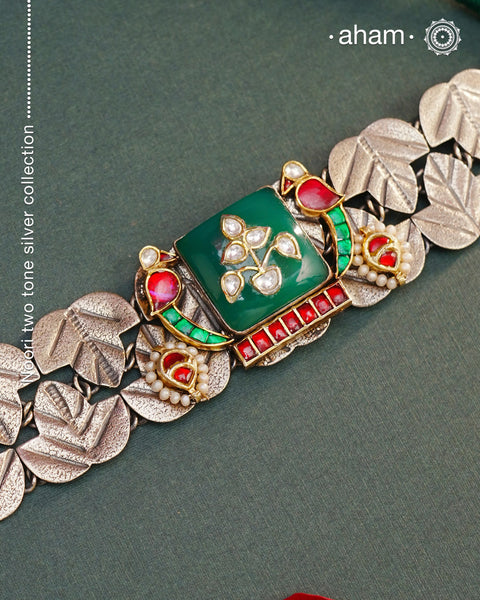 Elevate your style with the Noori Parrot Two Tone Silver Choker. This captivating piece features intricately crafted parrots and a stunning green stone, all set in 92.5 silver with two tones. Versatile and timeless, it is the perfect addition to any outfit. Invest in this modern heirloom for years to come.