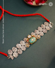 Discover the beauty of the Noori Two Tone Silver Choker. Versatile and unique, this wearable art piece is crafted in 92.5 silver with two tones and embellished with two parrots and a beautiful stone at its center. With kundan and pearl highlights, this modern heirloom will be cherished for generations.