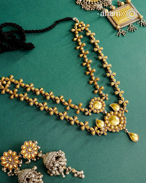 Enhance your style with the timeless elegance of the Dual Tone Silver Neckpiece. Handcrafted by skilled karigars in Barmer, Rajasthan, this earring features traditional Bandhel work, where a thin sheet of hand beaten&nbsp;22 carat gold is fused with 92.5 silver and then set on 92.5 silver using a unique wax filling technique. A classic representation of Indian craftsmanship.