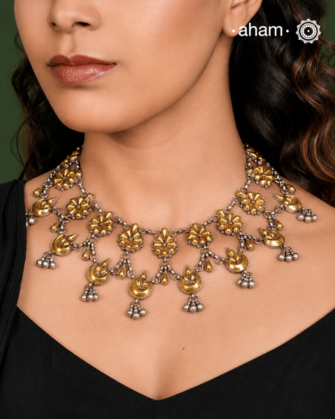 Enhance your style with the timeless elegance of the Dual Tone Silver Neckpiece. Handcrafted by skilled karigars in Barmer, Rajasthan, this earring features traditional Bandhel work, where a thin sheet of hand beaten&nbsp;22 carat gold is fused with 92.5 silver and then set on 92.5 silver using a unique wax filling technique. A classic representation of Indian craftsmanship.&nbsp;