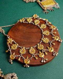 Enhance your style with the timeless elegance of the Dual Tone Silver Neckpiece. Handcrafted by skilled karigars in Barmer, Rajasthan, this earring features traditional Bandhel work, where a thin sheet of hand beaten&nbsp;22 carat gold is fused with 92.5 silver and then set on 92.5 silver using a unique wax filling technique. A classic representation of Indian craftsmanship.