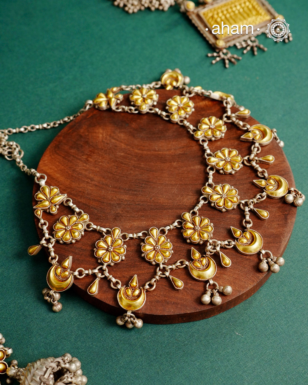 Enhance your style with the timeless elegance of the Dual Tone Silver Neckpiece. Handcrafted by skilled karigars in Barmer, Rajasthan, this earring features traditional Bandhel work, where a thin sheet of hand beaten 22 carat gold is fused with 92.5 silver and then set on 92.5 silver using a unique wax filling technique. A classic representation of Indian craftsmanship.
