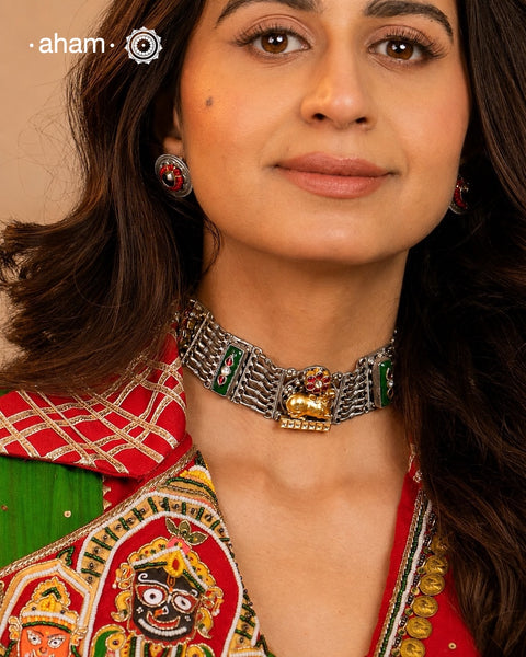 A singular artistic creation, this Nandi choker exemplifies masterful silversmithing. Executed in dual-tone silver with kundan inlay work, it presents a sophisticated composition of layered textures and chromatic variation. The piece demonstrates refined technical execution through its balanced interplay of sculptural forms and ornamental detailing. Conceived as a generational heirloom, its timeless construction and versatile aesthetic ensure enduring relevance across occasions and eras, positioning it as b