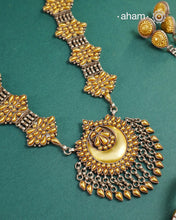 Enhance your style with the timeless elegance of the Dual Tone Silver Neckpiece. Handcrafted by skilled karigars in Barmer, Rajasthan, this earring features traditional Bandhel work, where a thin sheet of hand beaten&nbsp;22 carat gold is fused with 92.5 silver and then set on 92.5 silver using a unique wax filling technique. A classic representation of Indian craftsmanship.