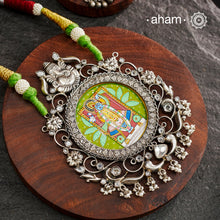 This hand-painted Shreenathji neckpiece is a true piece of art. The miniature Shreenathji is carefully painted by master artisans, set in silver with kundan work and strung on a comfortable cotton thread. Add a touch of culture and beauty to your outfit with this unique silver neckpiece.