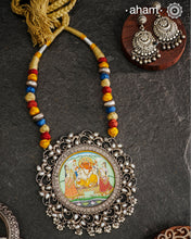 This hand-painted Ganesha neckpiece is a true piece of art. The miniature Ganesha is carefully painted by master artisans, set in silver with beautiful pearl work all around it and strung on a comfortable cotton thread. Add a touch of culture and beauty to your outfit with this unique silver neckpiece.