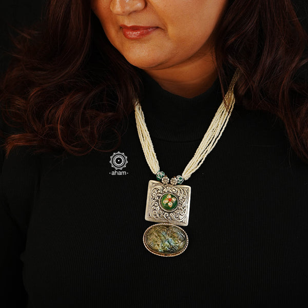 This one of a kind Ira Silver Neckpiece features a unique sterling silver pendant with chitai work, carved stone, and an inlay work green stone highlight. The pendant is perfectly complemented with strands of pearls for a timelessly elegant look.