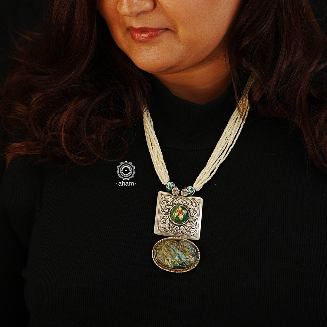 This one of a kind Ira Silver Neckpiece features a unique sterling silver pendant with chitai work, carved stone, and an inlay work green stone highlight. The pendant is perfectly complemented with strands of pearls for a timelessly elegant look.