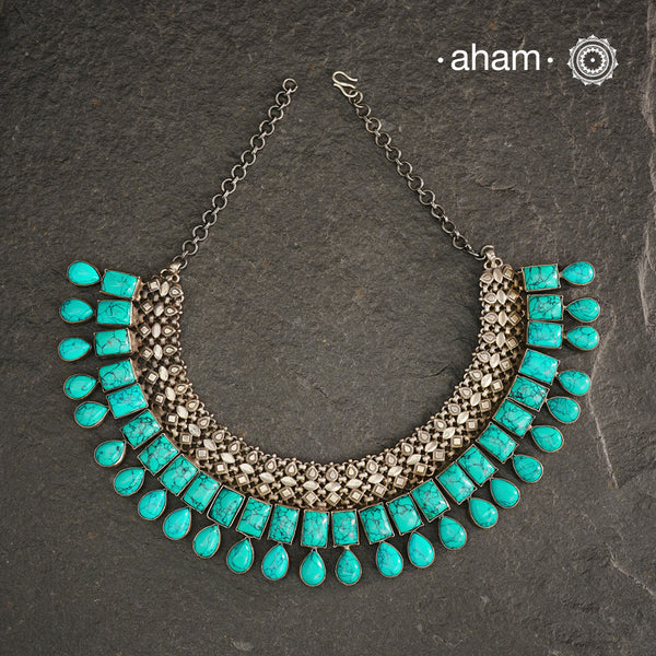 The Ira Turquoise Silver Neckpiece showcases the perfect harmony between vibrant turquoise and oxidised 92.5% sterling silver. Meticulously handcrafted, this exquisite piece offers a bold yet elegant statement, designed to elevate your look and ensure you stand out effortlessly. Ideal for those who value timeless craftsmanship and distinctive style.