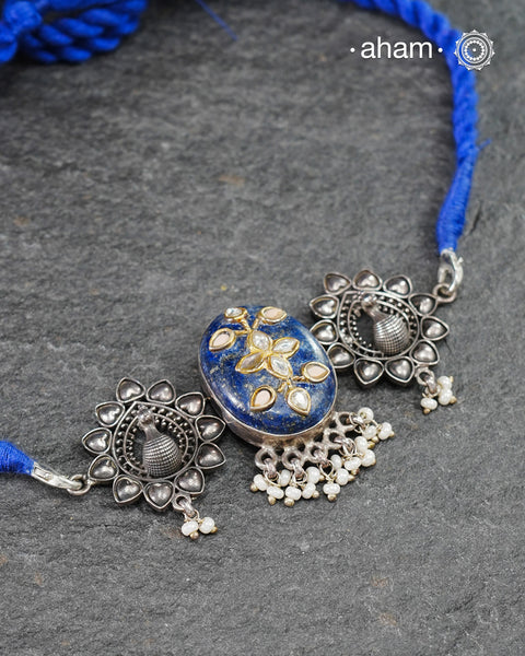 This Ira choker features a stunning lapiz center with intricate kundan inlay work flanked by peacocks on both sides, elegantly crafted in 92.5 silver. Adorn any outfit with this delicate and timeless piece. Guaranteed to add a touch of sophistication and charm to your look.