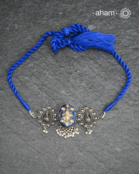This Ira choker features a stunning lapiz center with intricate kundan inlay work flanked by peacocks on both sides, elegantly crafted in 92.5 silver. Adorn any outfit with this delicate and timeless piece. Guaranteed to add a touch of sophistication and charm to your look.