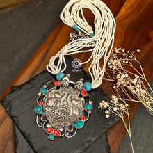 Crafted in 92.5 silver, the Ira Peacock Silver Neckpiece features a stunning peacock pendant adorned with turquoise and coral highlights. Elegant faux pearl strings complete this exquisite piece, making it perfect for any occasion. Elevate your style with this beautiful neckpiece.