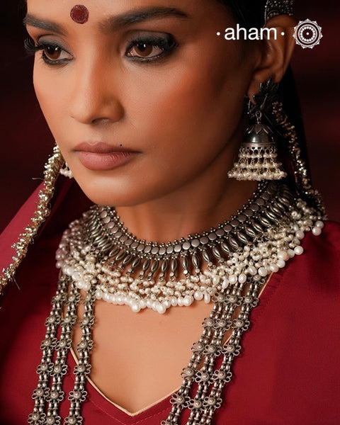 This 92.5 silver Ira neckpiece exemplifies understated elegance through meticulous craftsmanship. Fresh water pearl beads delicately laces the sterling silver, creating a sophisticated piece that sits gracefully below the neck. A testament to minimalist design principles and artisanal jewellery-making techniques.