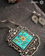 Make a bold statement with the Ira Turquoise Silver Neckpiece! This stunning piece features a vibrant turquoise stone set in silver with intricate inlay work and kundan all around it.&nbsp; Delicate flowers decorate the chain, all crafted in 92.5 silver. Elevate your style and stand out from the crowd with this unique necklace.