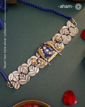 Discover the beauty of the Noori Two Tone Silver Choker. Simple yet unique, this wearable art piece is crafted in 92.5 silver with two tones and embellished with two parrots and lapiz at its center. With kundan and pearl highlights, this modern heirloom will be cherished for generations.