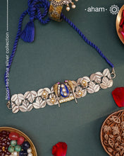 Discover the beauty of the Noori Two Tone Silver Choker. Simple yet unique, this wearable art piece is crafted in 92.5 silver with two tones and embellished with two parrots and lapiz at its center. With kundan and pearl highlights, this modern heirloom will be cherished for generations.