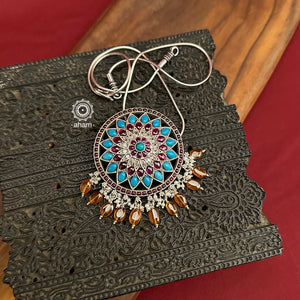 Beautiful Nrityam Pendant crafted in silver with turquoise and kemp highlights, laced with beautiful brown stones and pearls. Wear it with a silver chain, a halsi or with beads of your choice.