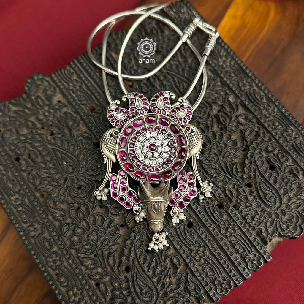 Nrityam Silver Pendant. Comes with beautiful traditional motifs of Ambi, Parrot and Nandi, studded with kemp stones. Wear it with a silver chain, silver hasli  or a black thread.