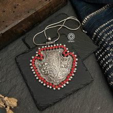 Statement silver pendant handcrafted in 92.5 silver with intricate floral chitai work from Rajasthan, comes with coral and pearl stone highlights. Wear it with a long silver chain or with cotton thread, to pair with your formal Indian outfits.  Does not include Chain.