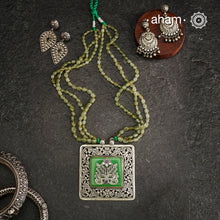 The Ira Silver Neckpiece features masterful chitai work with precise silver cutwork that sits on a luminous green center stone. The pendant is complemented by a strand of carefully selected semi-precious stone beads, enhancing its visual complexity. This exceptional piece demonstrates superior silversmithing techniques while offering a sophisticated aesthetic that transitions effortlessly from traditional to contemporary settings.