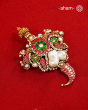An exquisite interplay of elements comes together in this one-of-a-kind pendant. Featuring a luminous baroque pearl at the centre, framed by peacocks on either side, delicate fish motifs, and a tiger tooth detail at the base, it is crafted in 92.5 silver with a gold polish finish. Accented with deep pink and green kundan work and finished with delicate pearl detailing, this pendant is designed to make a distinctive statement. Works great with a Hasli&nbsp;