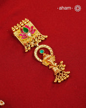 A striking pendant inspired by traditional symbolism and intricate craftsmanship. Featuring a beautifully detailed Ganesha motif suspended below a lotus adorned with deep pink and green kundan work, this piece celebrates artistry in every detail. Crafted in 92.5 silver with a rich gold polish finish, delicate ghungroo accents add movement and charm, making it a distinctive statement for festive and occasion wear..