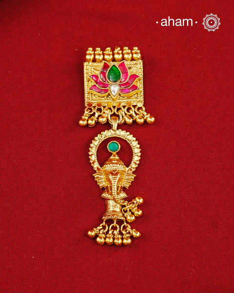 A striking pendant inspired by traditional symbolism and intricate craftsmanship. Featuring a beautifully detailed Ganesha motif suspended below a lotus adorned with deep pink and green kundan work, this piece celebrates artistry in every detail. Crafted in 92.5 silver with a rich gold polish finish, delicate ghungroo accents add movement and charm, making it a distinctive statement for festive and occasion wear..