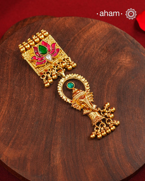 A striking pendant inspired by traditional symbolism and intricate craftsmanship. Featuring a beautifully detailed Ganesha motif suspended below a lotus adorned with deep pink and green kundan work, this piece celebrates artistry in every detail. Crafted in 92.5 silver with a rich gold polish finish, delicate ghungroo accents add movement and charm, making it a distinctive statement for festive and occasion wear..