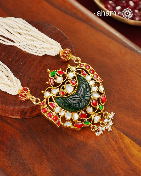 Fine Kundan work pendant in 92.5 silver with gold polish. Beautiful carved green stone in the center. Comes with faux pearl beads.