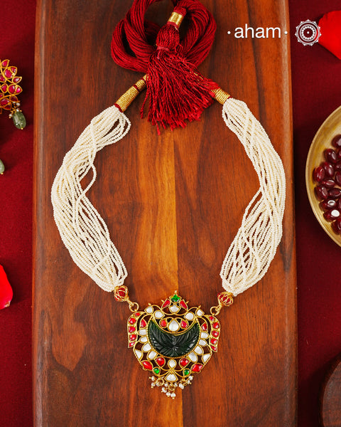 Fine Kundan work pendant in 92.5 silver with gold polish. Beautiful carved green stone in the center. Comes with faux pearl beads.