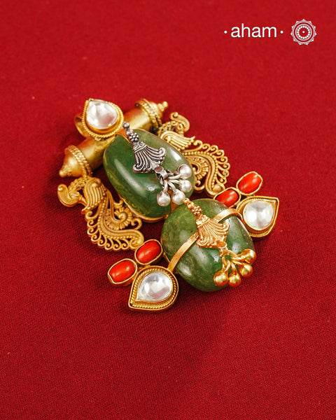 A harmonious composition of heritage-inspired elements, this statement pendant brings together tumble emeralds, coral accents, kundan highlights, and intricately detailed motifs in a beautifully layered form. The sculptural design, enhanced with delicate silver detailing and a rich gold polish finish, evokes the charm of vintage jewellery while feeling strikingly distinctive. Crafted in 92.5 silver, this pendant is perfect for adding an artistic, conversation-worthy touch to festive and occasion wear.