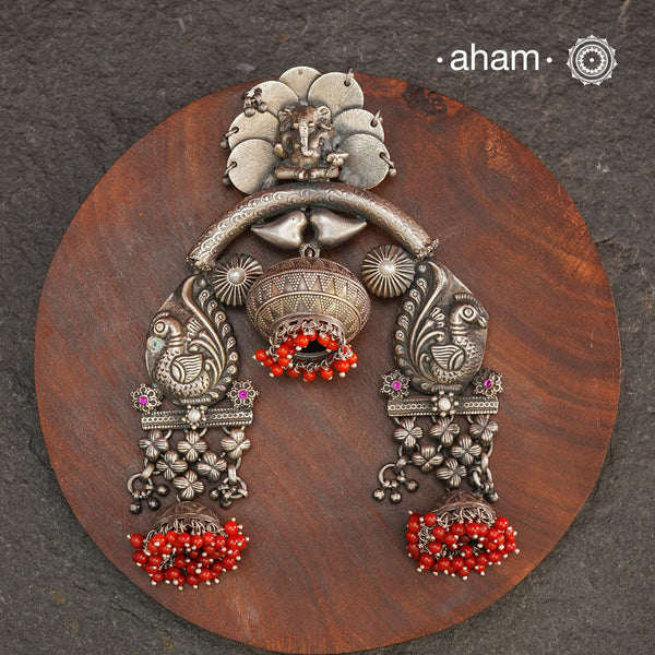 Crafted in 92.5 silver, this large statement Ganesha pendant is truly one of a kind. Featuring beautiful peacocks and coral highlights, it's a unique piece that will make a bold and elegant addition to any outfit. Elevate your style with this exquisite silver pendant.