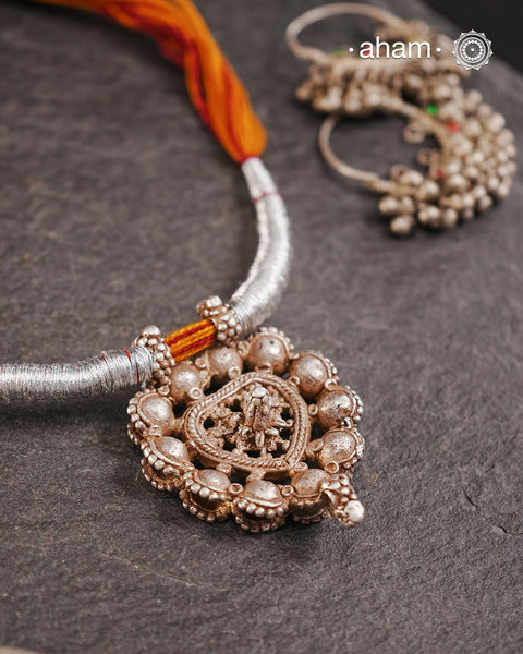 This finely crafted tribal silver amulet pendant, originating from Madhya Pradesh, reflects the heritage and stories of a bygone era. It is accompanied by a striking thread powai, enhancing its traditional appeal.