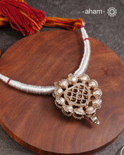 This finely crafted tribal silver amulet pendant, originating from Madhya Pradesh, reflects the heritage and stories of a bygone era. It is accompanied by a striking thread powai, enhancing its traditional appeal.