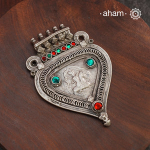 Beautiful handcrafted Arrowhead tribal silver pendant with Bhumiya Raja, (Bhumiya Raja- the brave tribal chief who died defending his village) stamped in the center, A piece from a bygone area, that bring back memories and stories of that time. The pendant has some beautiful stone highlights that bring out the beauty of the piece even more. Wear it with a long chain or with a black thread, or layer them to create a distinct look.