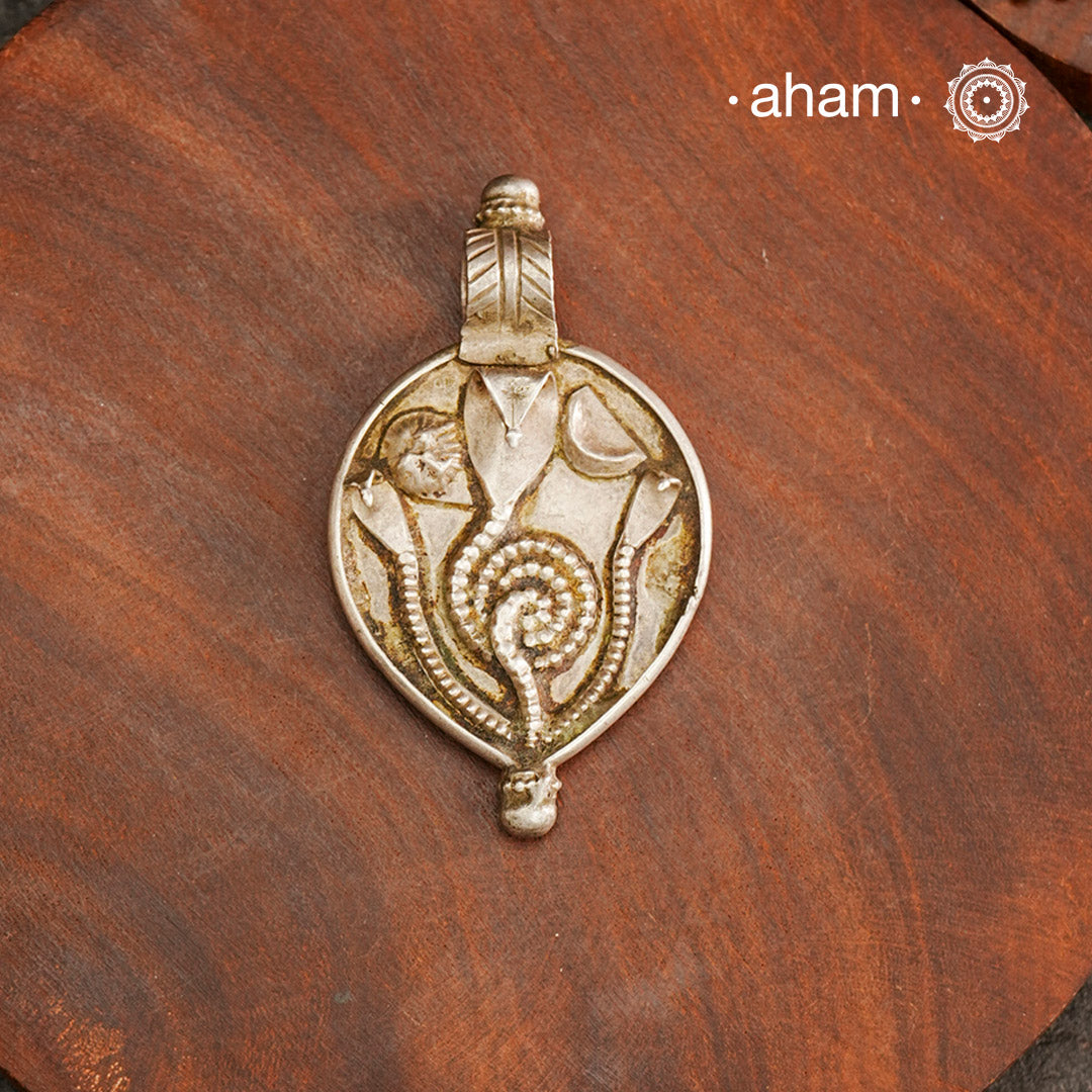 Tribal Silver Snake Pendant, a beautifully handcrafted tribal silver pendant from a bygone area, that bring back memories and stories of that time. Wear it with a long chain or with a black thread, or layer them to create a distinct look. This Amulet reflects a beautiful blend of faith and craftsmanship — a perfect representation of heritage jewellery.