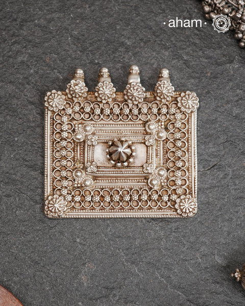 Representative of a traditional Indian home, this vintage House amulet is an architectural pendant that represents shelter, stability, and divine presence within the home. Represented by a walled-in Square and a center courtyard along with ornate decorations, it is a powerful symbol of family unity and protection. This pendant is hand crafted in silver This Beautiful handcrafted tribal silver amulet pendant from a bygone area brings back memories and stories of that time.