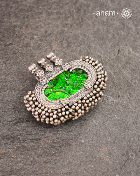 Tribal Silver pendant with beautiful green glass center and lots of tinny ghungroos tied all around. Crafted in Silver&nbsp;