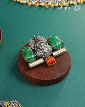 This exquisite Two Tone Silver Pendant showcases stunning krishna nakshi work accented with a vibrant emerald tumble stone and kundan highlights. Handcrafted in 92.5 silver, it is truly one of a kind. Elevate any outfit with its unique and beautiful design.