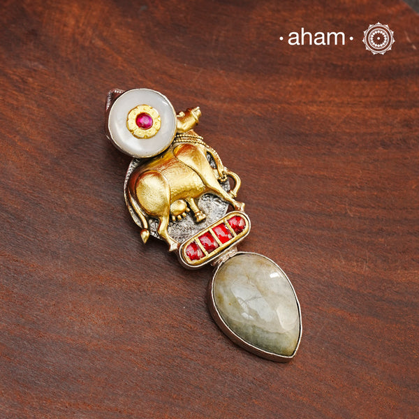 This Noori dual tone silver pendant combines royalty and artistry in one exquisite piece. Handcrafted in 92.5 sterling silver, it features nature-inspired motifs including a stunning cow motif, a semi-precious stone drop, and mother of pearl accents. Elevate any outfit with this meticulously crafted pendant.

Chain not included