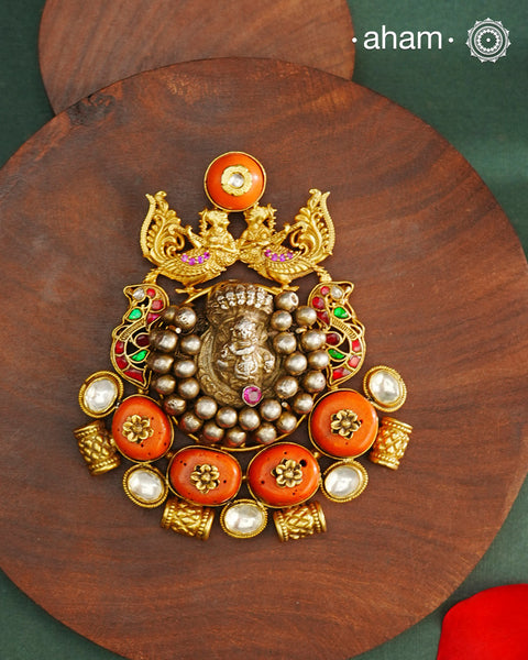 This exquisite Two Tone Silver Pendant showcases stunning krishna nakshi work accented with peacocks and vibrant coral stone and kundan highlights. Handcrafted in 92.5 silver, it is truly one of a kind. Elevate any outfit with its unique and beautiful design.