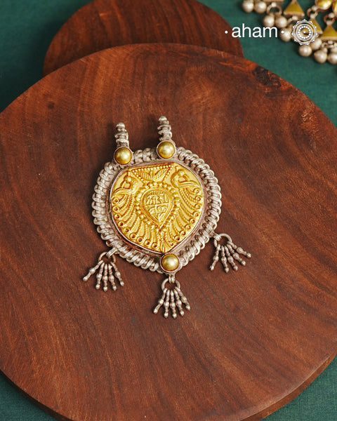 Enhance your style with the timeless elegance of the Dual Tone Silver Pendant. Handcrafted by skilled karigars in Barmer, Rajasthan, this neckpiece features traditional Bandhel work, where a thin sheet of hand beaten&nbsp;22 carat gold is set on 92.5 silver using a unique wax setting technique. A classic representation of fine Indian traditional craftsmanship.