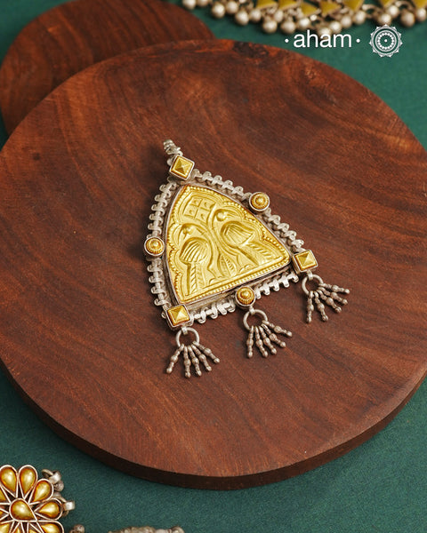 Enhance your style with the timeless elegance of the Dual Tone Silver Pendant. Handcrafted by skilled karigars in Barmer, Rajasthan, this neckpiece features traditional Bandhel work, where a thin sheet of hand beaten&nbsp;22 carat gold is set on 92.5 silver using a unique wax setting technique. A classic representation of fine Indian traditional craftsmanship.&nbsp;

Chain not included