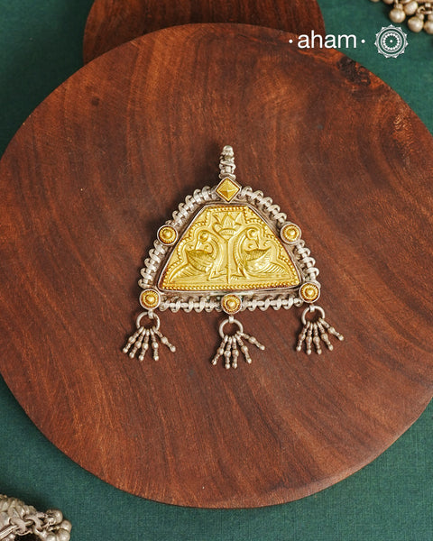 Enhance your style with the timeless elegance of the Dual Tone Silver Pendant. Handcrafted by skilled karigars in Barmer, Rajasthan, this neckpiece features traditional Bandhel work, where a thin sheet of hand beaten 22 carat gold is set on 92.5 silver using a unique wax setting technique. A classic representation of fine Indian traditional craftsmanship. 

Chain not included