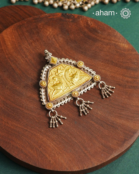 Enhance your style with the timeless elegance of the Dual Tone Silver Pendant. Handcrafted by skilled karigars in Barmer, Rajasthan, this neckpiece features traditional Bandhel work, where a thin sheet of hand beaten&nbsp;22 carat gold is set on 92.5 silver using a unique wax setting technique. A classic representation of fine Indian traditional craftsmanship.&nbsp;

Chain not included